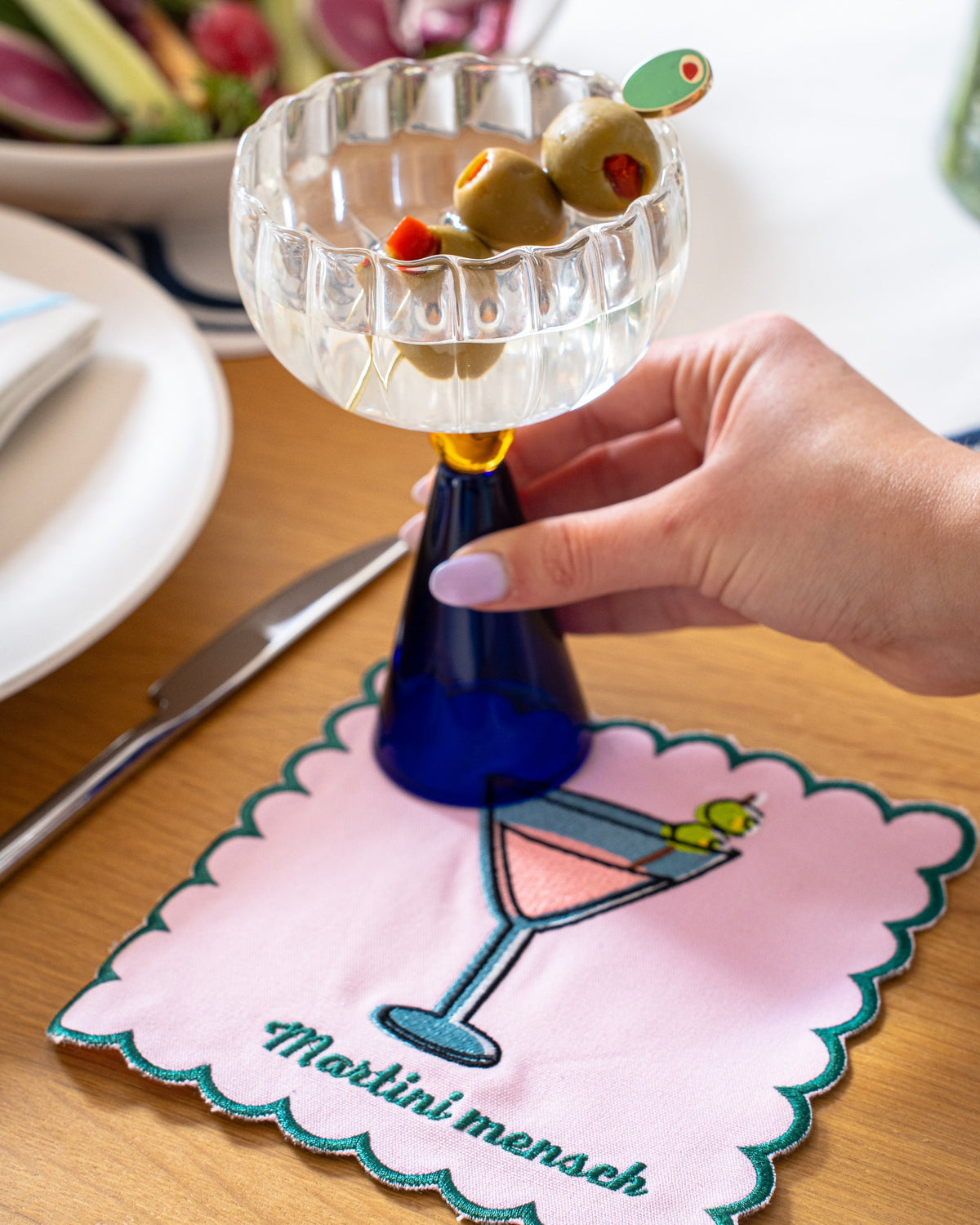 Martini Mensch embroidered cocktail napkin styled with a martini