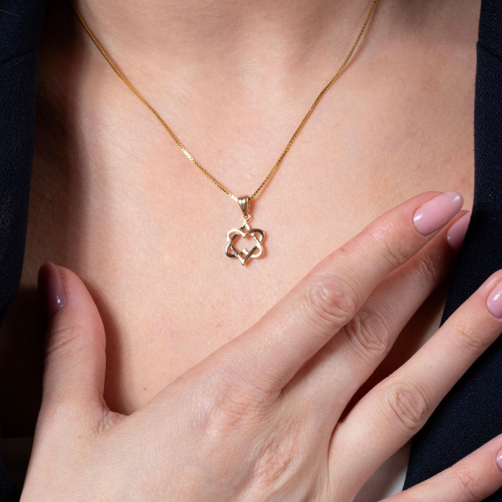 Gold necklace with a heart-shaped pendant worn by a woman