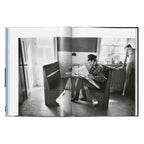 Daniel Kramer photograph of Bob Dylan sitting at a table reading a newspaper in Woodstock