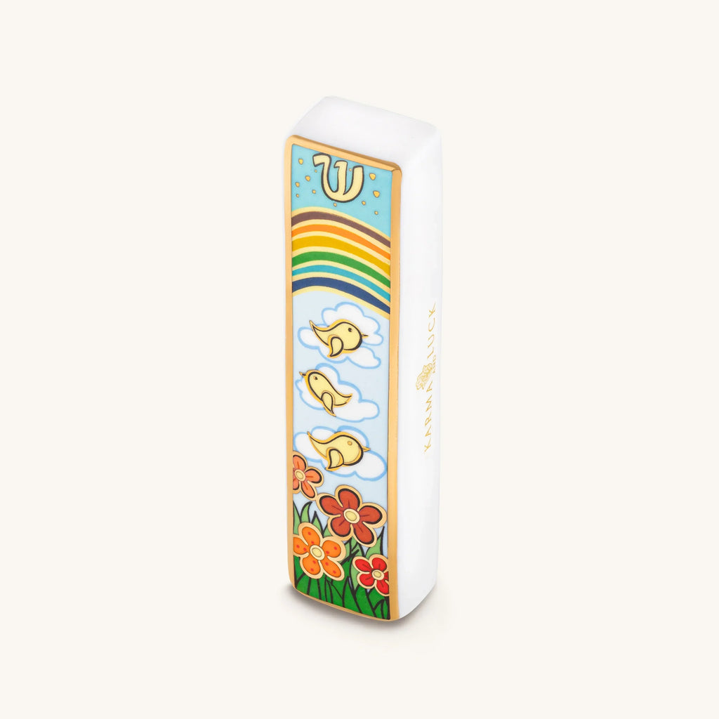 Bright Beginnings ceramic mezuzah with rainbow, birds and colorful flowers on a white case