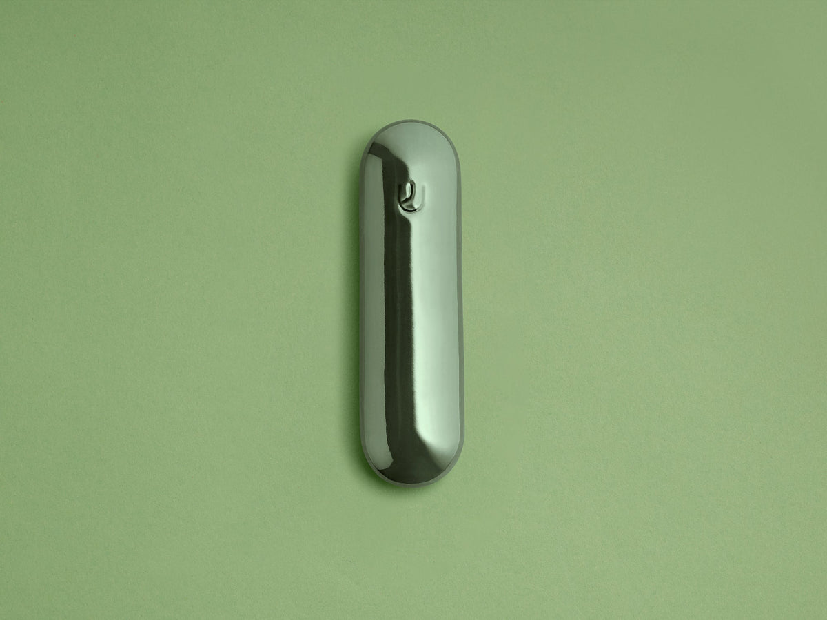 Fern Ceramic Pill Mezuzah shown upright against a green background