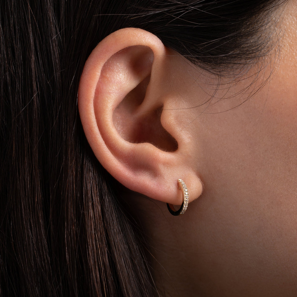 Diamond Huggie Earring shown on ear for scale