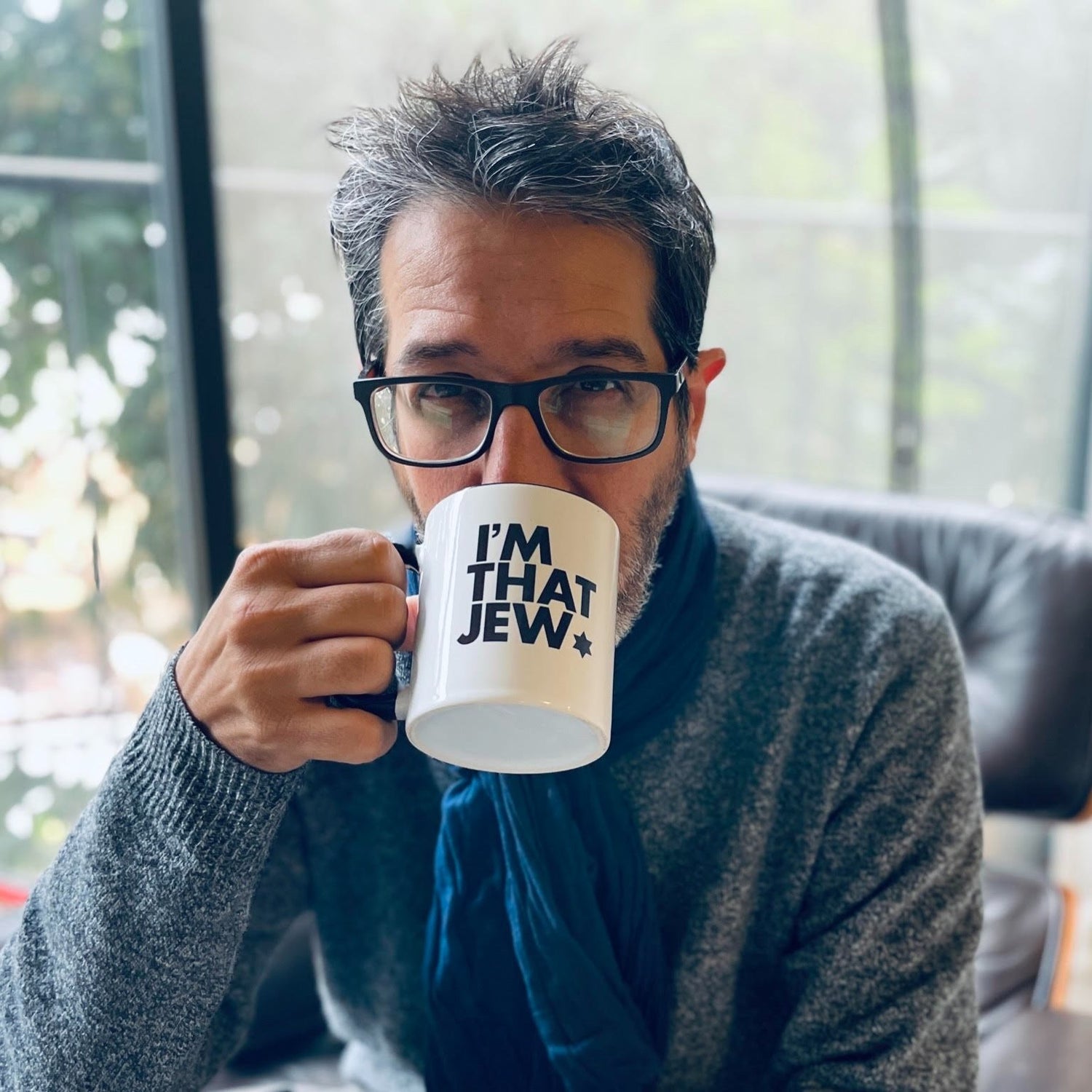 Eitan Chitayat drinking coffee from an "I'm That Jew" mug