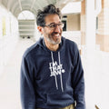 Man wearing a navy hoodie with 'I'm That Jew' text, standing indoors.