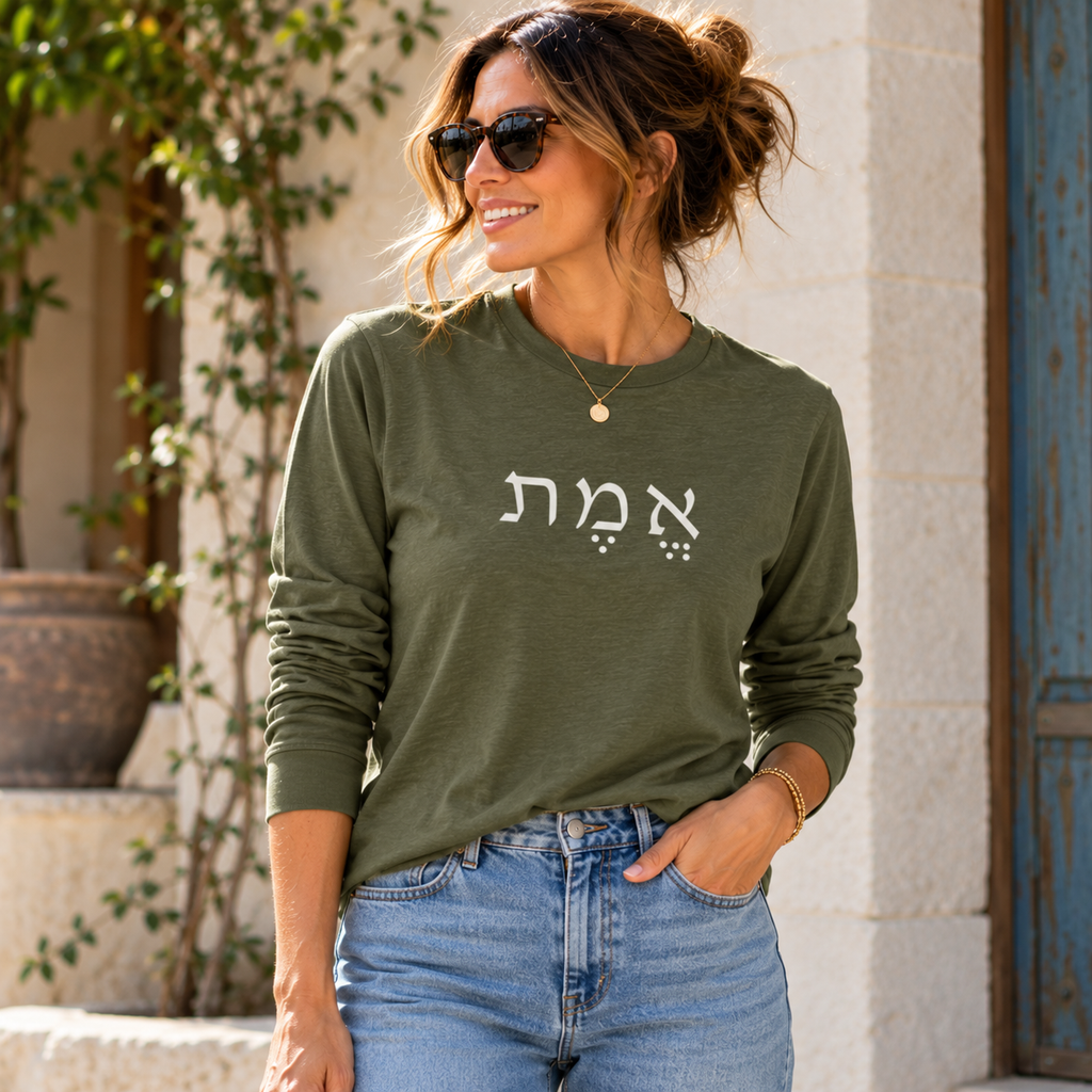 Woman wearing the olive Emet Hebrew long sleeve shirt by Poppy Lane with light wash jeans.
