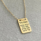 Gold necklace with a rectangular pendant on a gray background