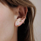 Model wearing gold Evie Post Earrings by Shlomit Ofir alongside layered gold earrings, showing the petite studs on the ear.