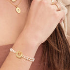 White Glory Bracelet with gold starburst pendant worn on the wrist