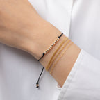 14K gold bead Fortune Bracelet with black cord worn on wrist