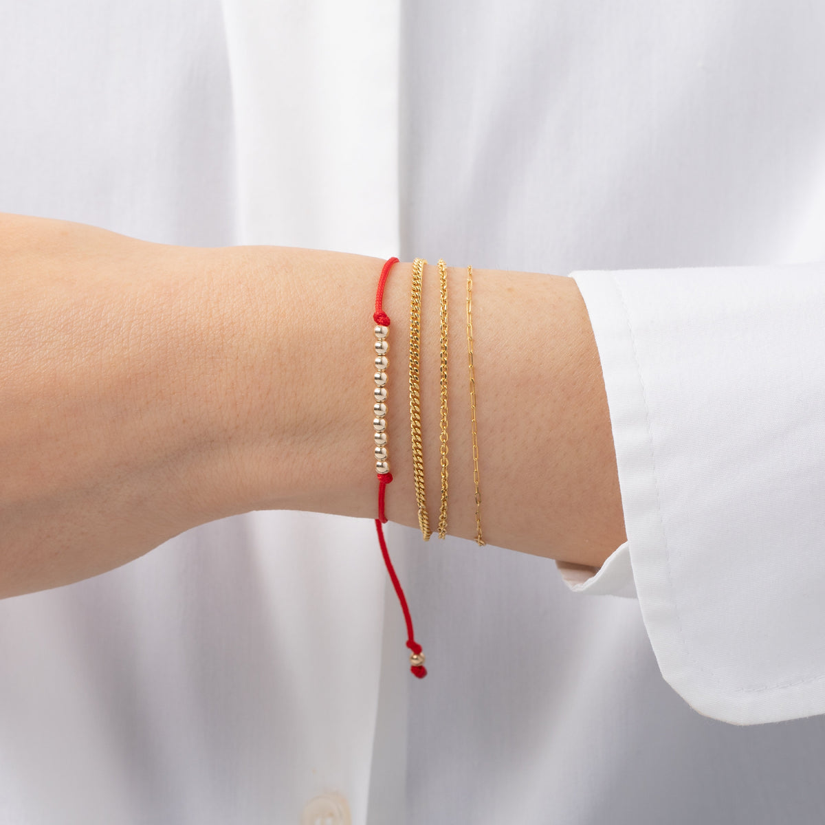 14K gold bead Fortune Bracelet with red cord worn on wrist