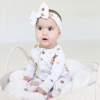 Baby wearing the Golden Hour Hanukkah bow with matching neutral Star of David pajamas.