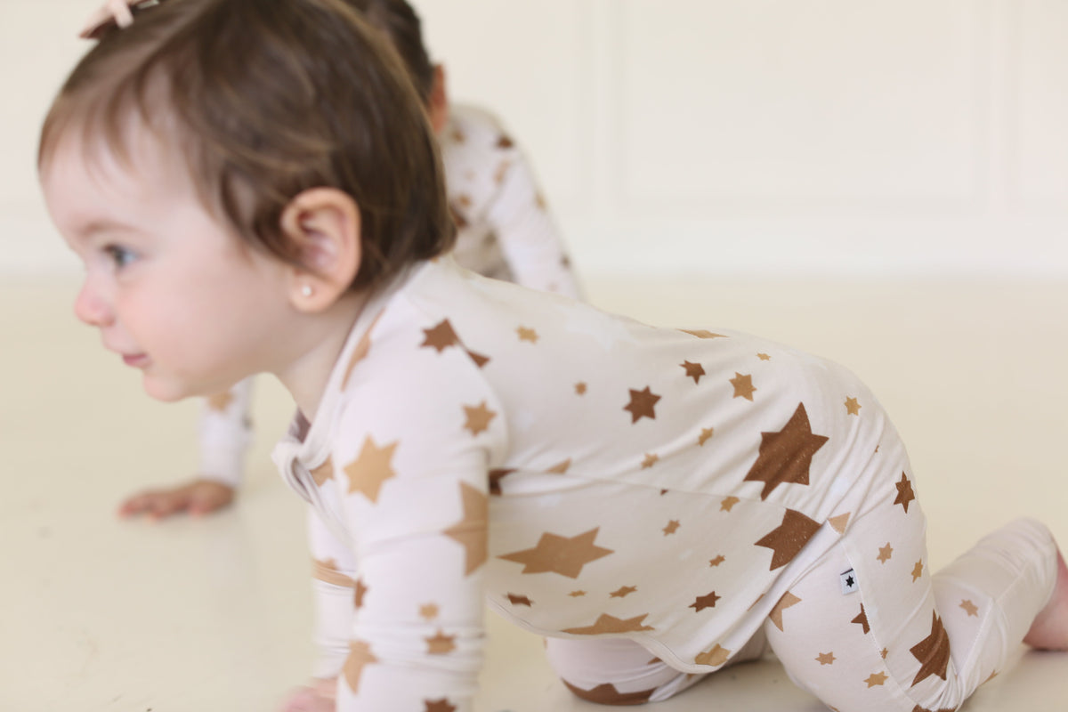 Baby crawling in the Golden Hour Hanukkah Zippy with neutral gold Star of David print.