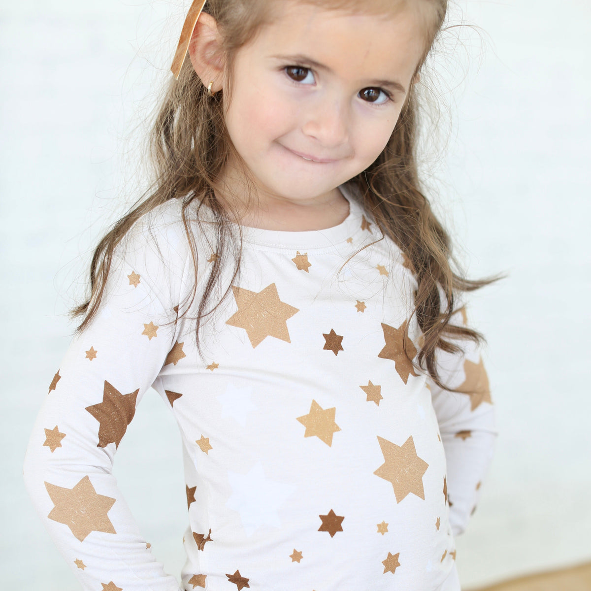 Close-up of child wearing Golden Hour Hanukkah pajamas with gold Star of David print.
