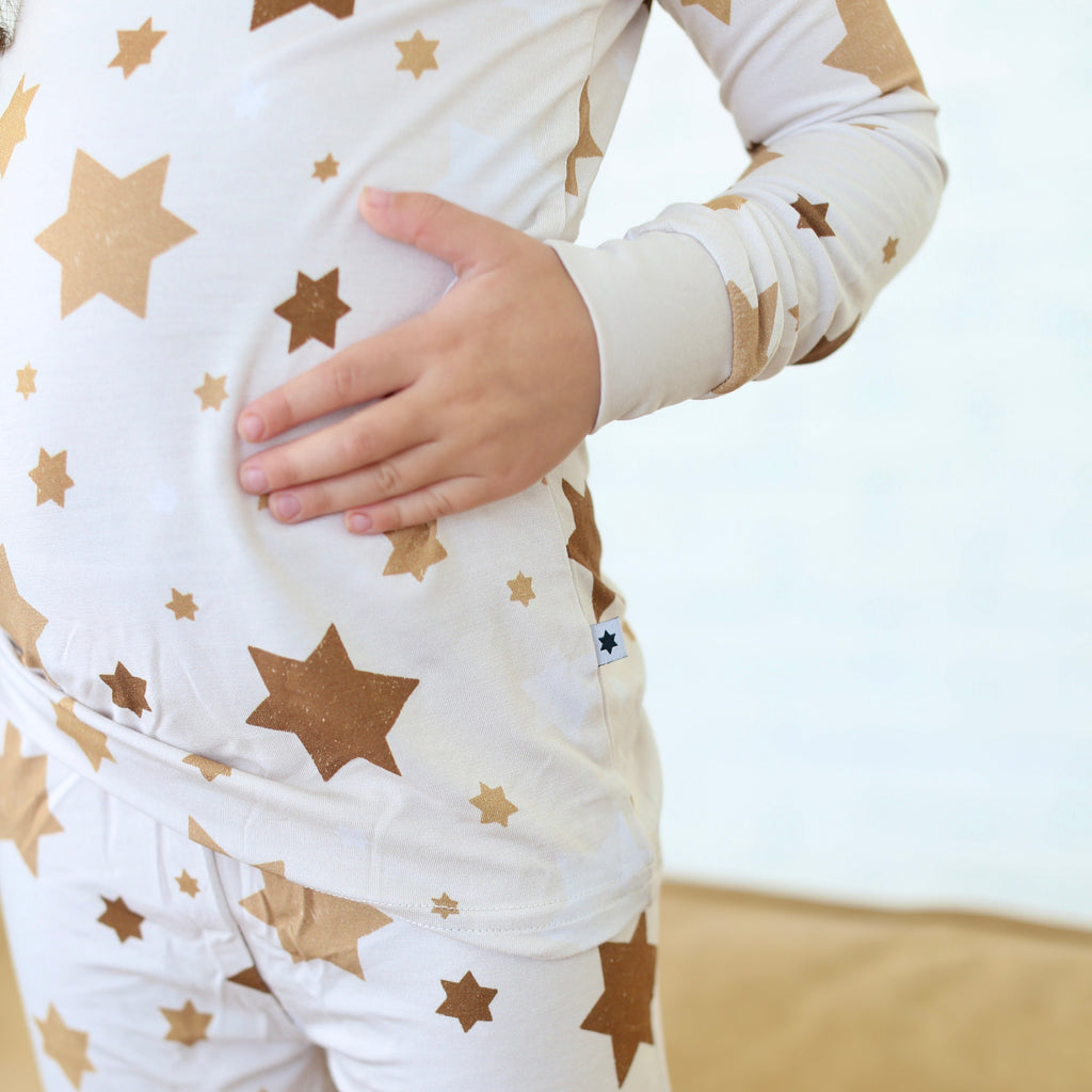 Close-up of Golden Hour Hanukkah two-piece pajamas with gold Star of David print.