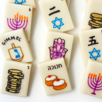 Hanukkah marzipan mahjong tiles featuring menorahs, dreidels, gelt, hamsas, sufganiyot, Hebrew lettering and Stars of David.