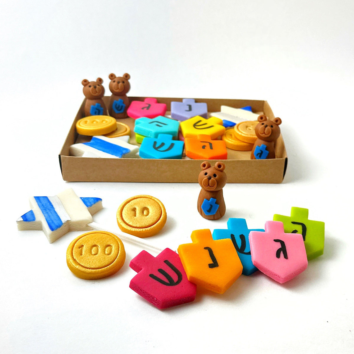 Hanukkah marzipan gift assortment with colorful dreidels, gold gelt, teddy bears and Star of David pops displayed with the gift box.