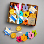 Hanukkah marzipan ultimate gift collection packaged in a ribbon-tied gift box with colorful dreidels, gold gelt and Star of David pops.