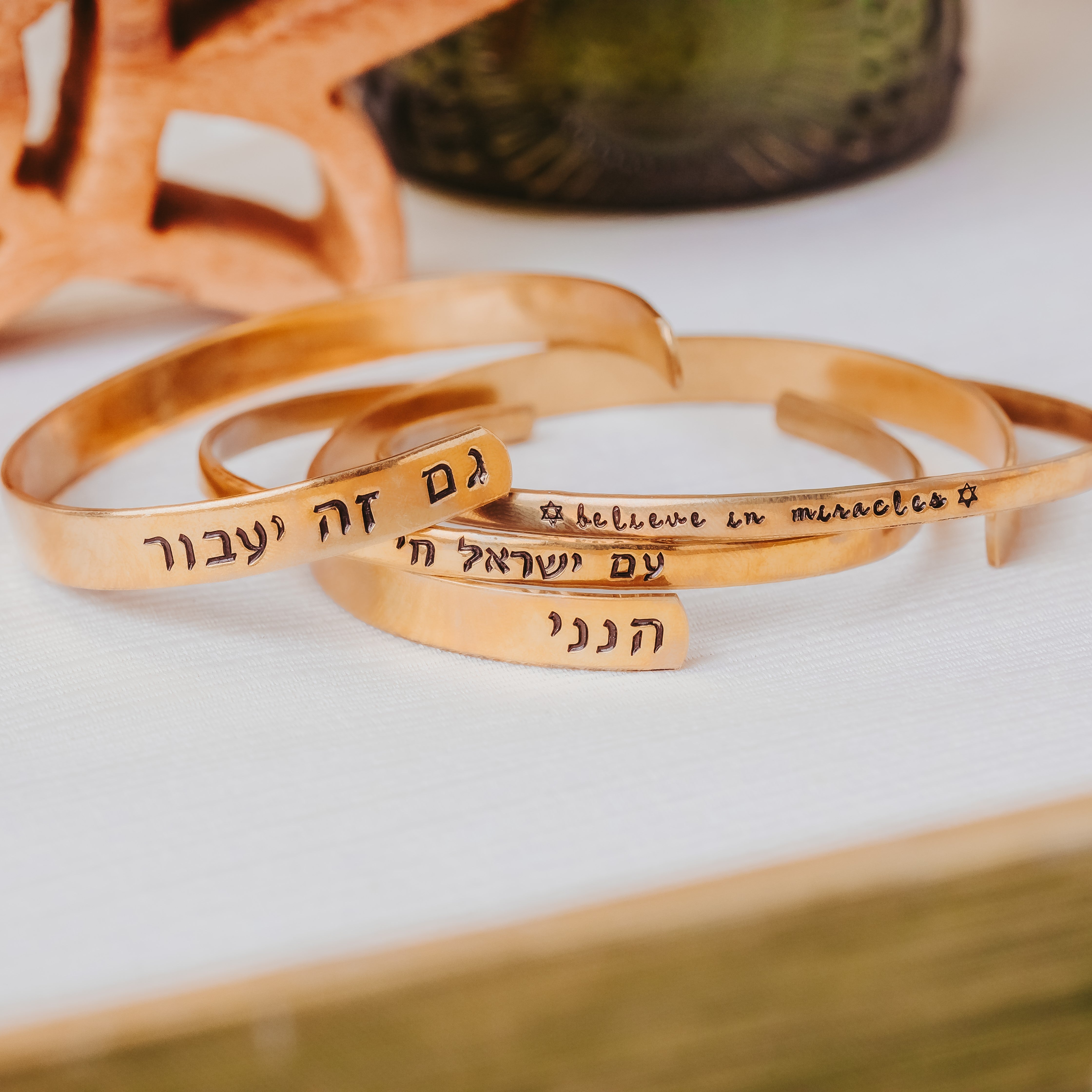 Hand-stamped Hebrew cuff bracelets in gold-tone metals