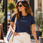 Woman wearing the navy Hineni T-shirt by Poppy Lane with cream jeans.
