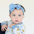 Baby wearing the blue Latkes & Light Hanukkah Bow with matching Shiloh & Kate pajamas.