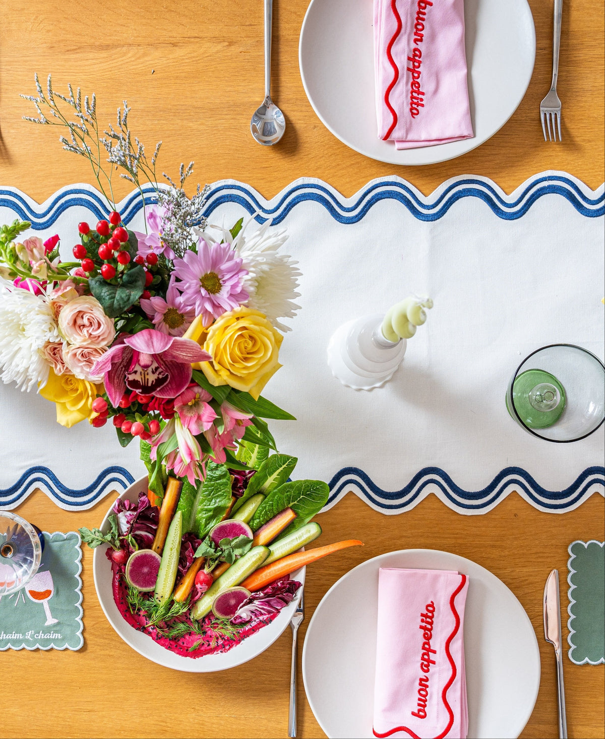 L’Chaim embroidered cocktail napkins styled on a colorful table set for entertaining.