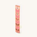 Love Lives Here ceramic heart mezuzah with pink and gold heart designs on white ceramic case
