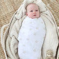 Newborn wrapped in the Magen Dreams swaddle blanket with a soft neutral Star of David print