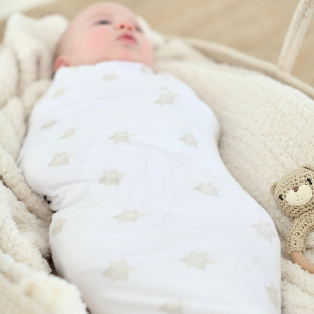 Full view of newborn wrapped in the Magen Dreams bamboo swaddle with neutral Star of David print