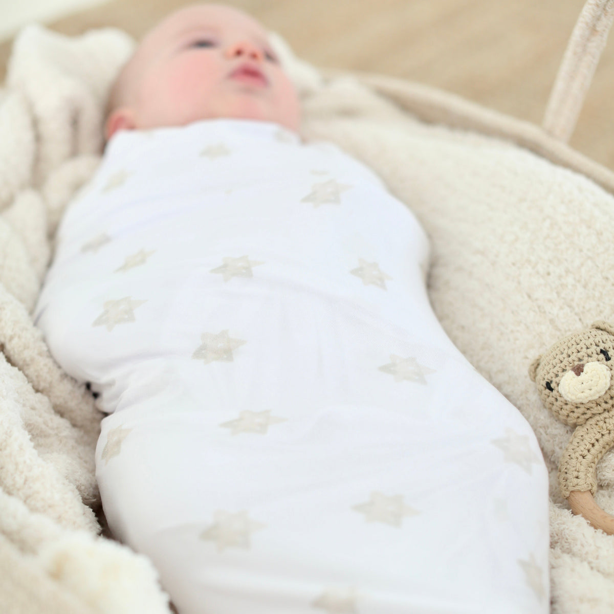 Full view of newborn wrapped in the Magen Dreams bamboo swaddle with neutral Star of David print