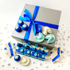 Hanukkah Elegant Gift Box tied with blue ribbon and surrounded by assorted blue and white marzipan treats