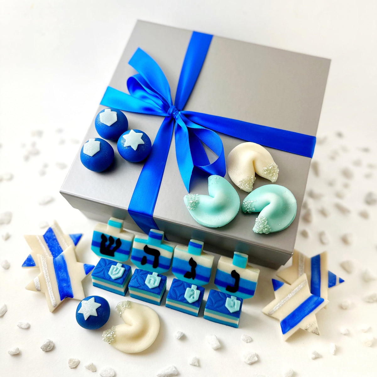 Hanukkah Elegant Gift Box tied with blue ribbon and surrounded by assorted blue and white marzipan treats