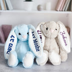 Blue and white personalized plush bunnies with children’s names in English and Hebrew on the ears