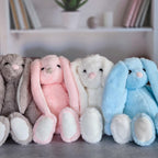 Grey, pink, white and blue plush bunnies displayed together to show available color options