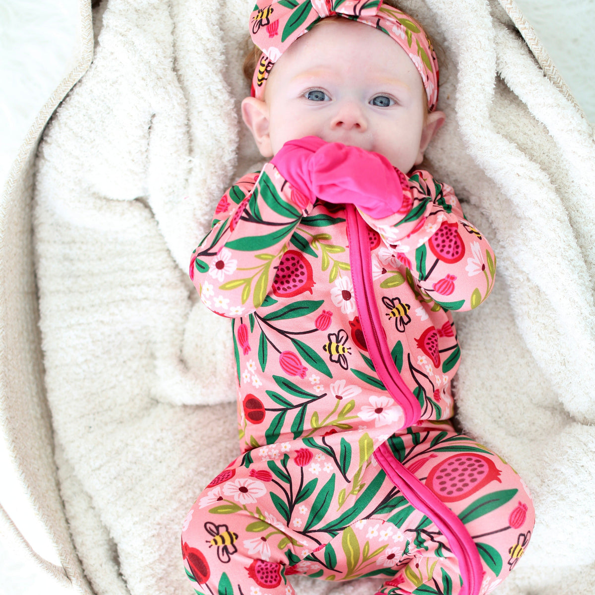 Baby wearing the Petals & Pomegranates zippy with pomegranates, florals and tiny honeybees