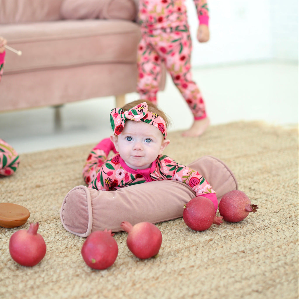 Baby in Petals & Pomegranates pajamas sitting with apples for Rosh Hashanah