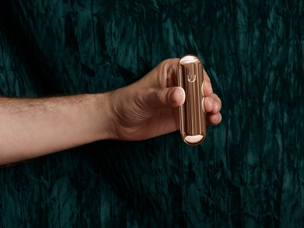 Rose Gold Pill Mezuzah held in hand to show scale