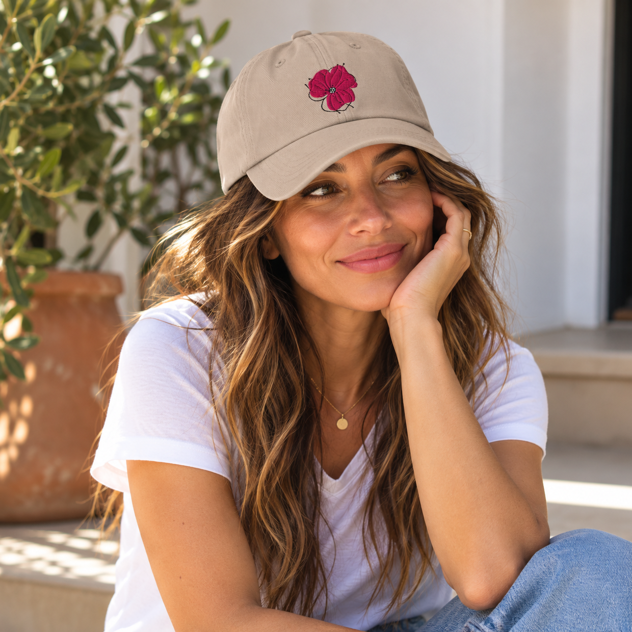 Woman wearing the Poppy Lane Poppy Hat in Stone with embroidered pink poppy