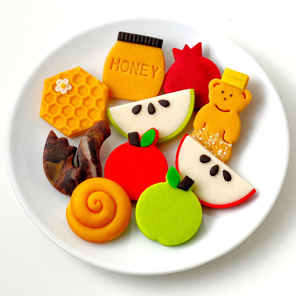 Assorted Rosh Hashanah marzipan treats arranged on a white plate by Marzipops