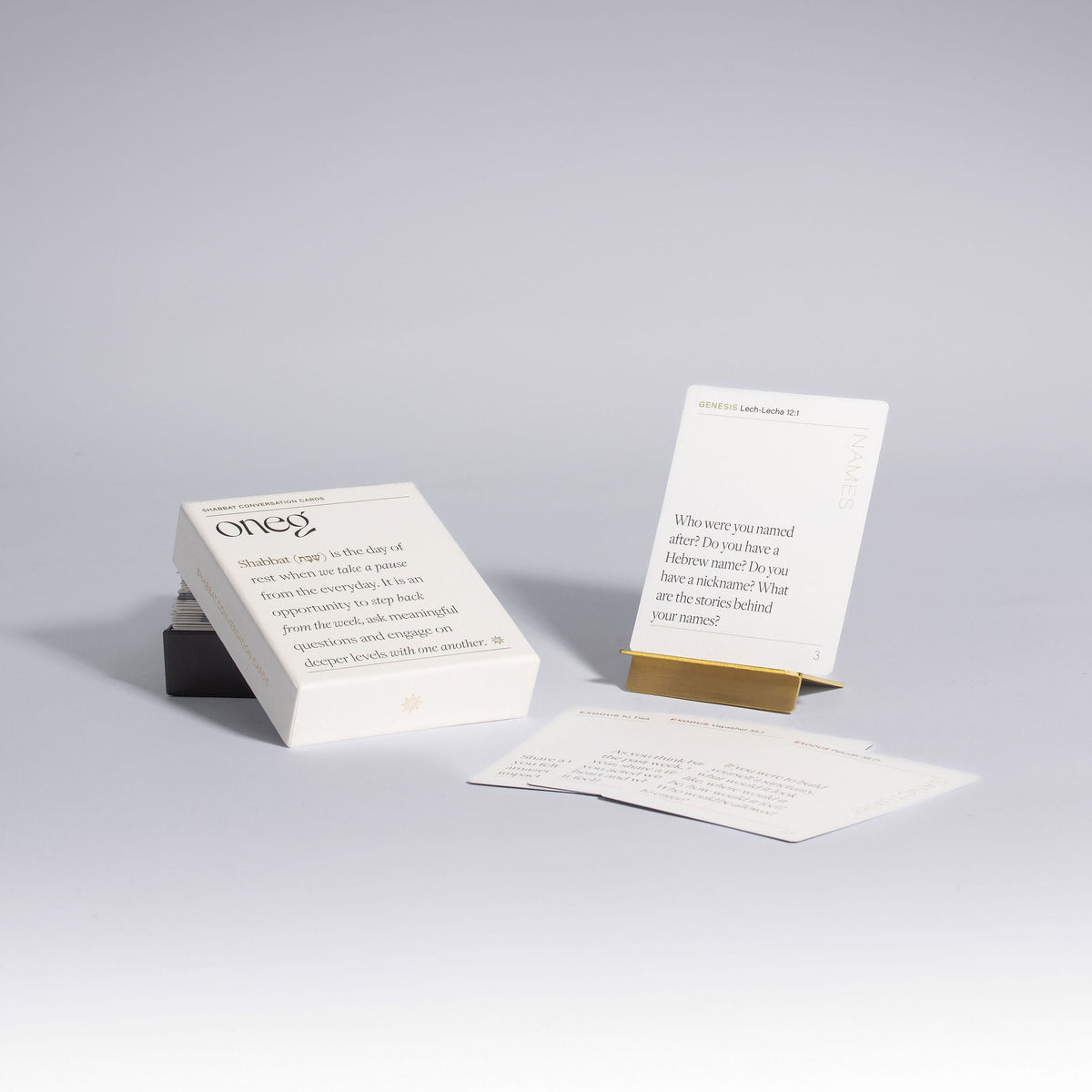Shabbat conversation prompt cards displayed with brass stand by Oneg