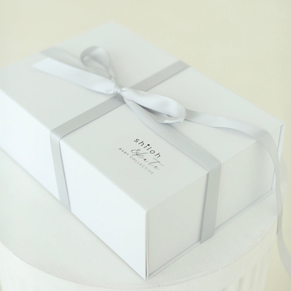 White Shiloh & Kate baby gift box tied with a satin ribbon, ready for gifting at a baby shower, bris, or baby naming.