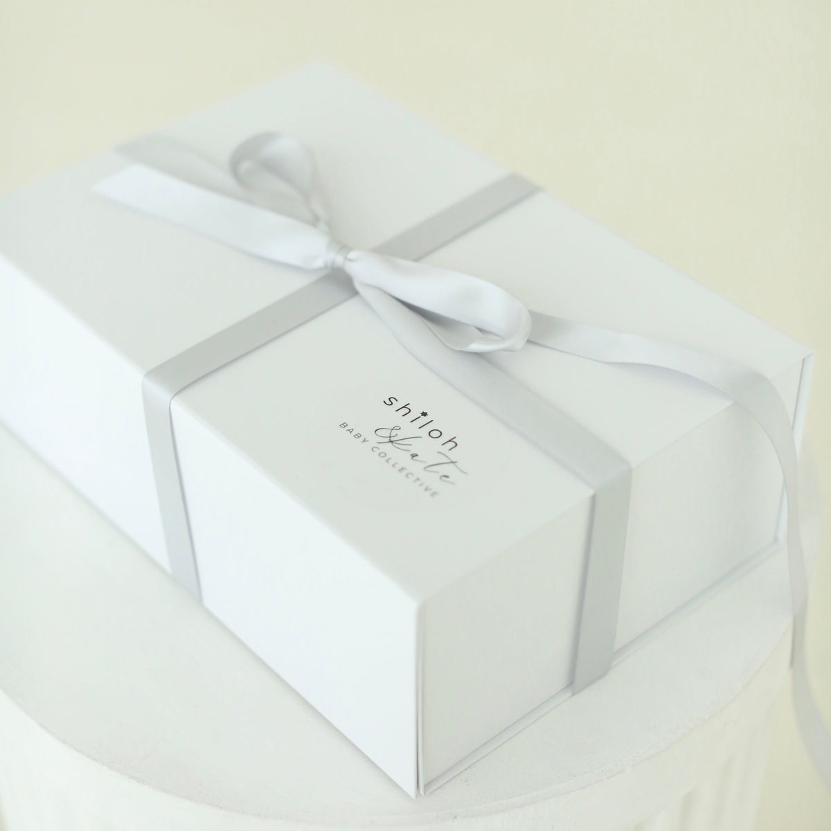White Shiloh & Kate baby gift box tied with a satin ribbon, ready for gifting at a baby shower, bris, or baby naming.