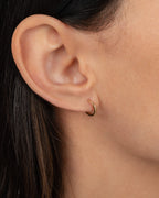 14K Gold Small Huggie Earrings worn on ear