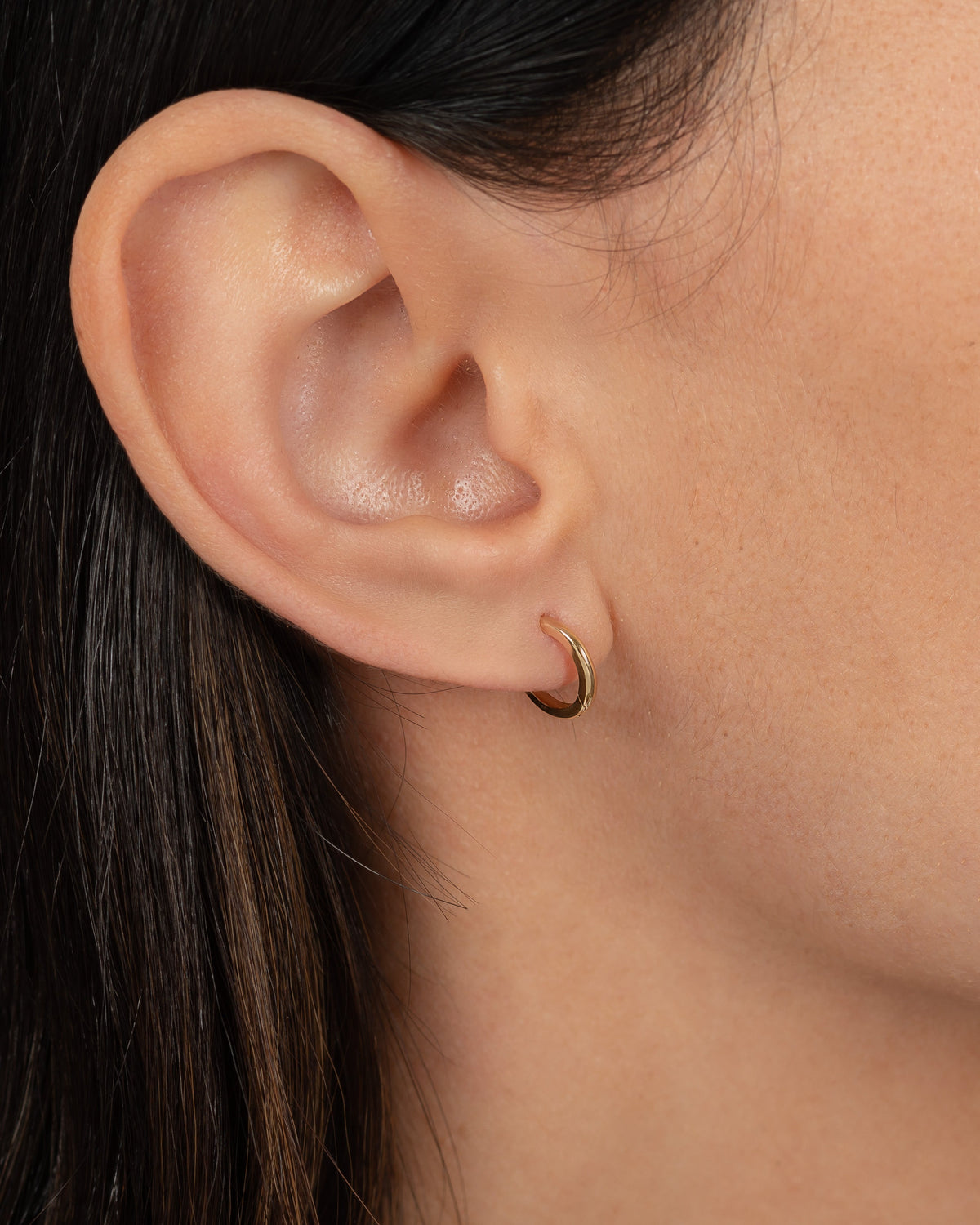 14K Gold Small Huggie Earrings worn on ear