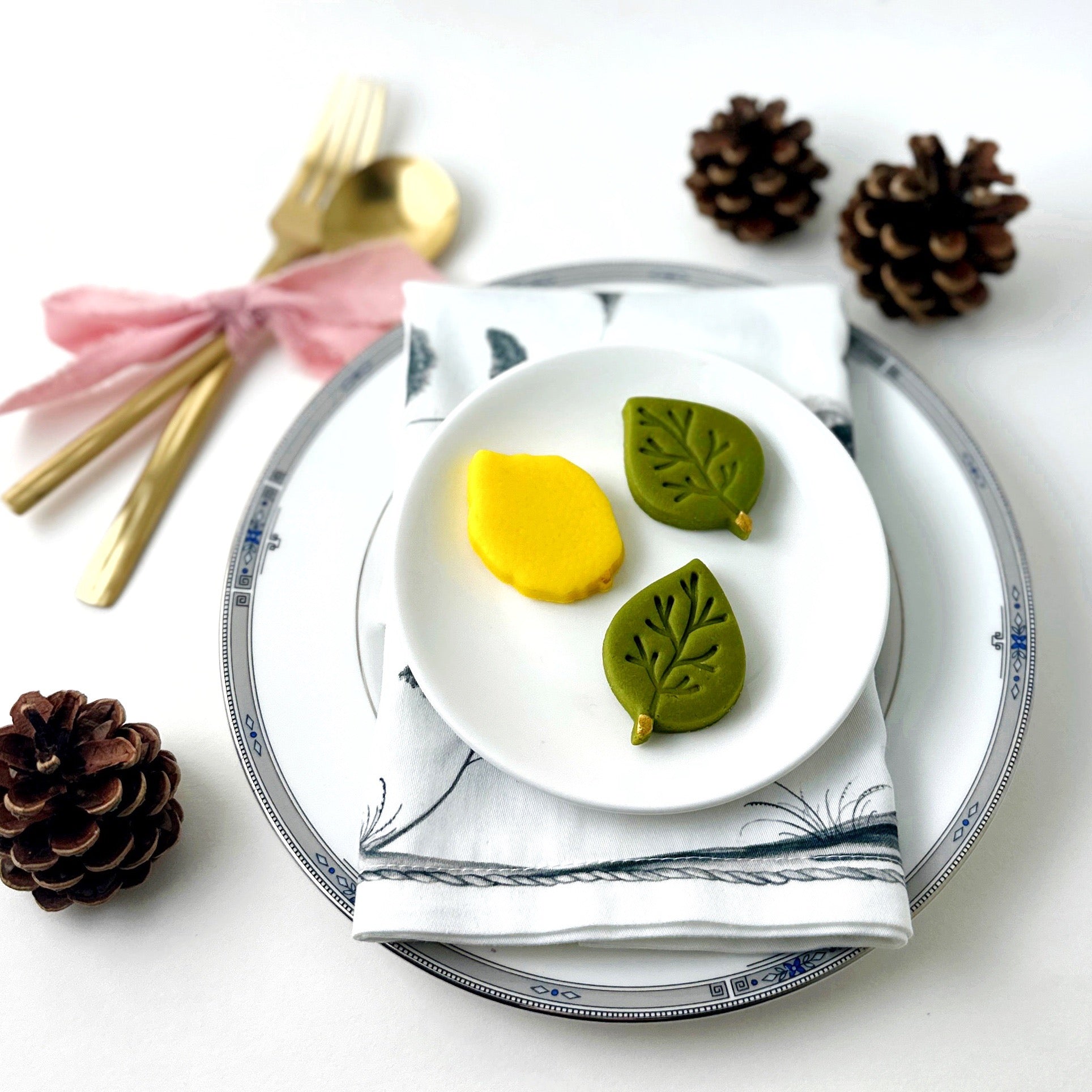 Marzipan etrog and green leaf treats displayed at a Sukkot place setting by Marzipops