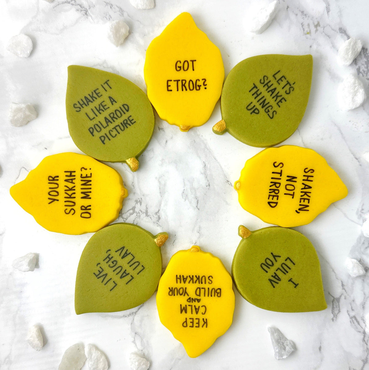 Handcrafted etrog and leaf marzipan tiles featuring funny Sukkot sayings and edible gold