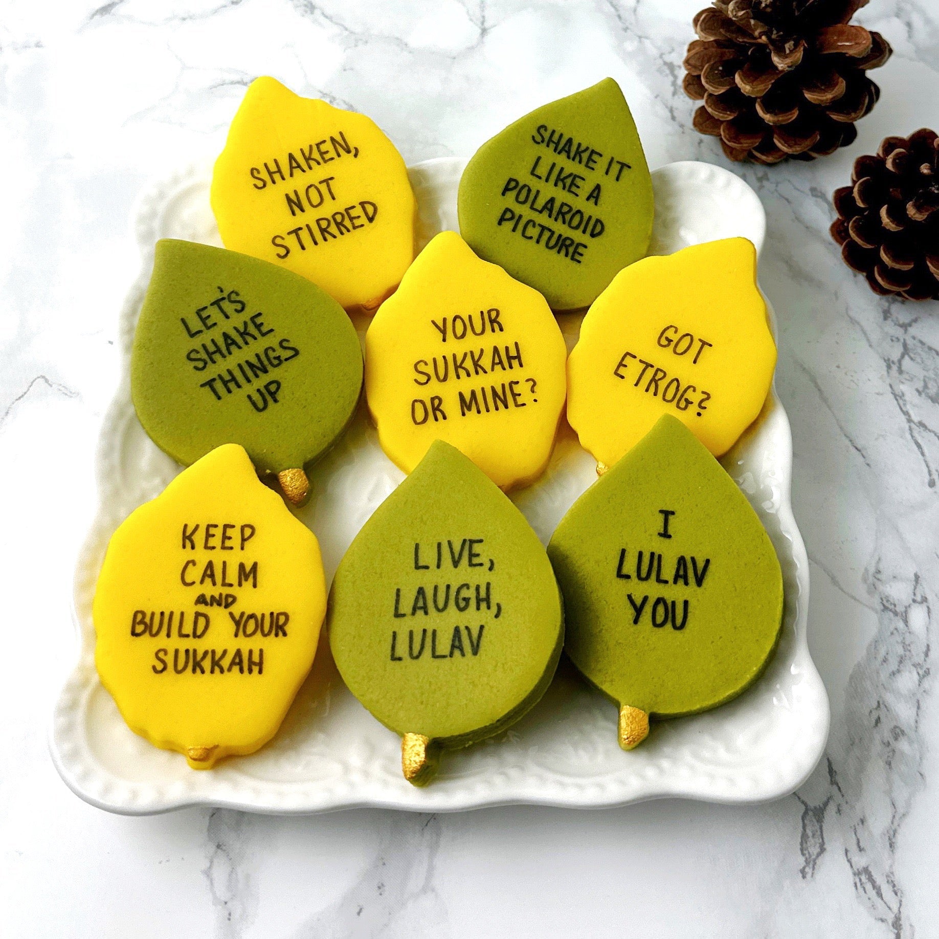 Assorted Sukkot marzipan conversation tiles shaped like etrogim and green leaves by Marzipops