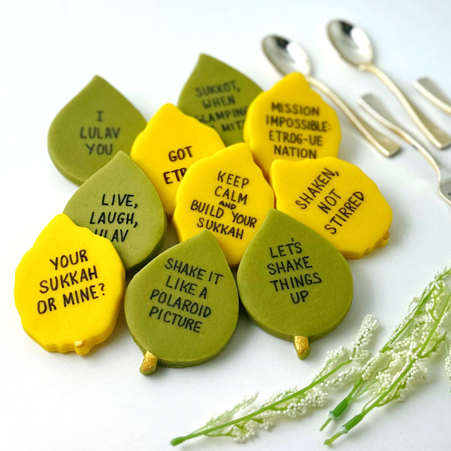 Sukkot marzipan conversation tiles arranged with silverware for a holiday table