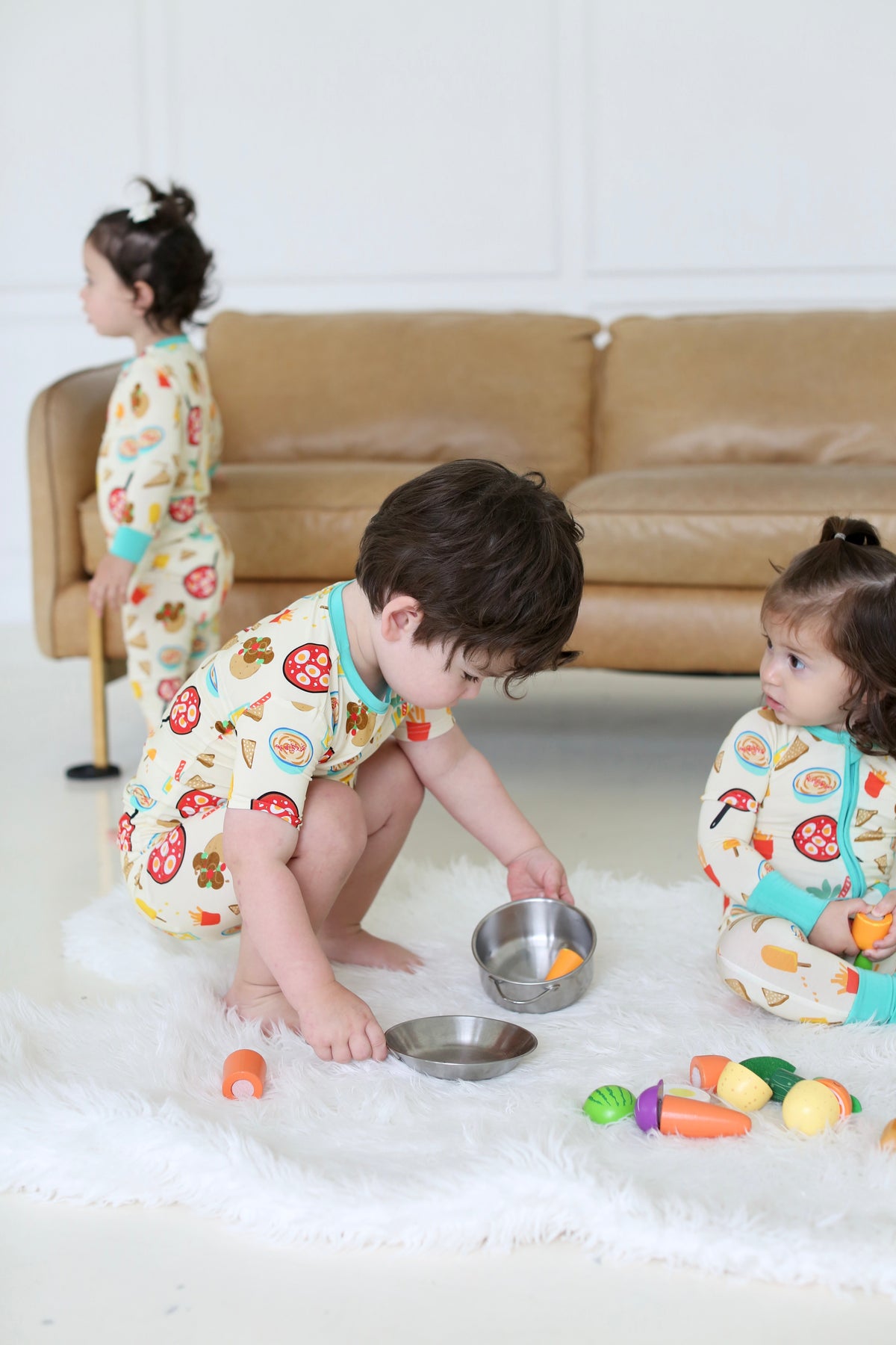 Children in matching Taste of Israel pajamas playing together on the floor