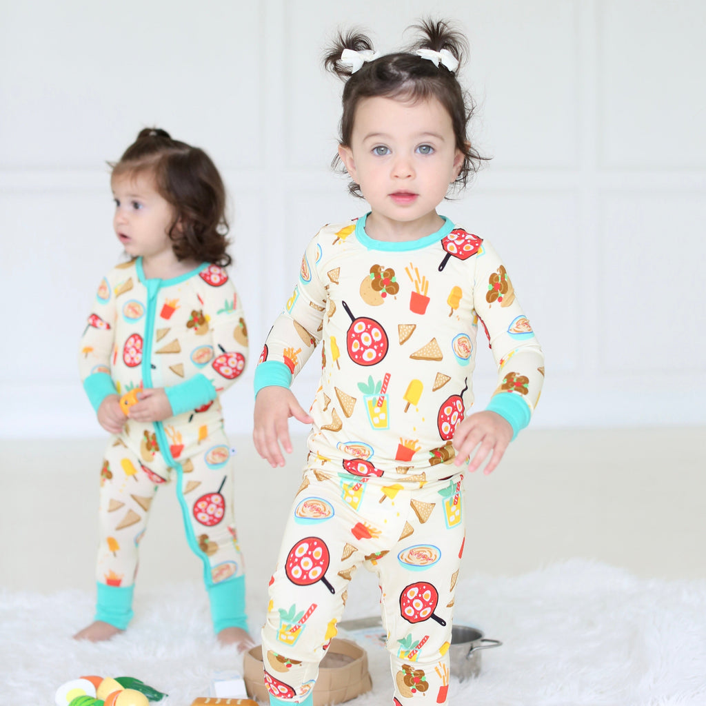 Young girl wearing the Taste of Israel two-piece pajamas with playful Israeli food illustrations