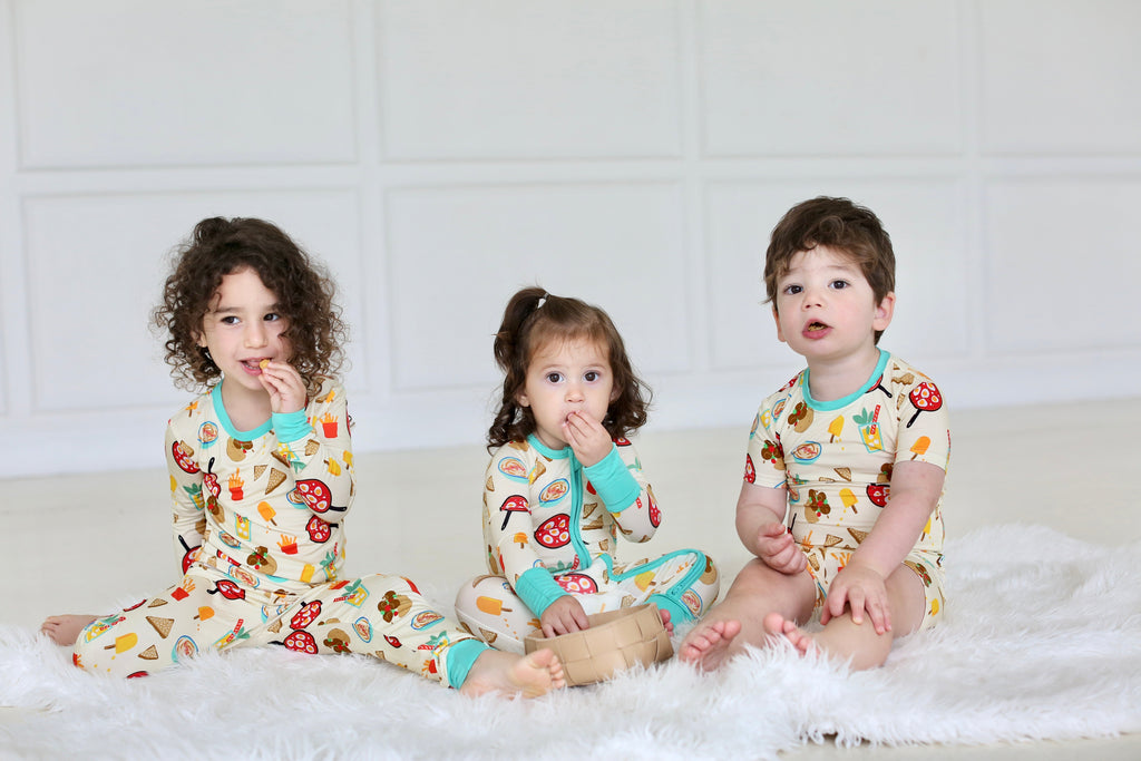 Children wearing coordinating Taste of Israel pajamas, including the baby zippy and two-piece set